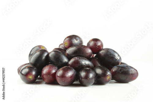 Pile of dark grapes isolated on white background. 