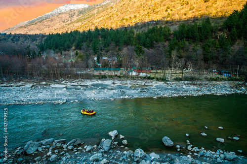 Rafting : boat moving on quiet river section-river Beas . next to Kullu town in Himachal Pradesh., India