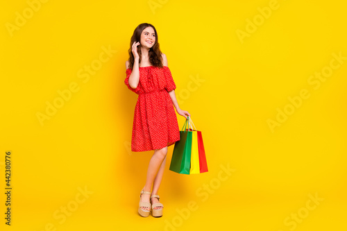 Full size portrait of pretty positive lady hand touch hair look empty space isolated on yellow color background