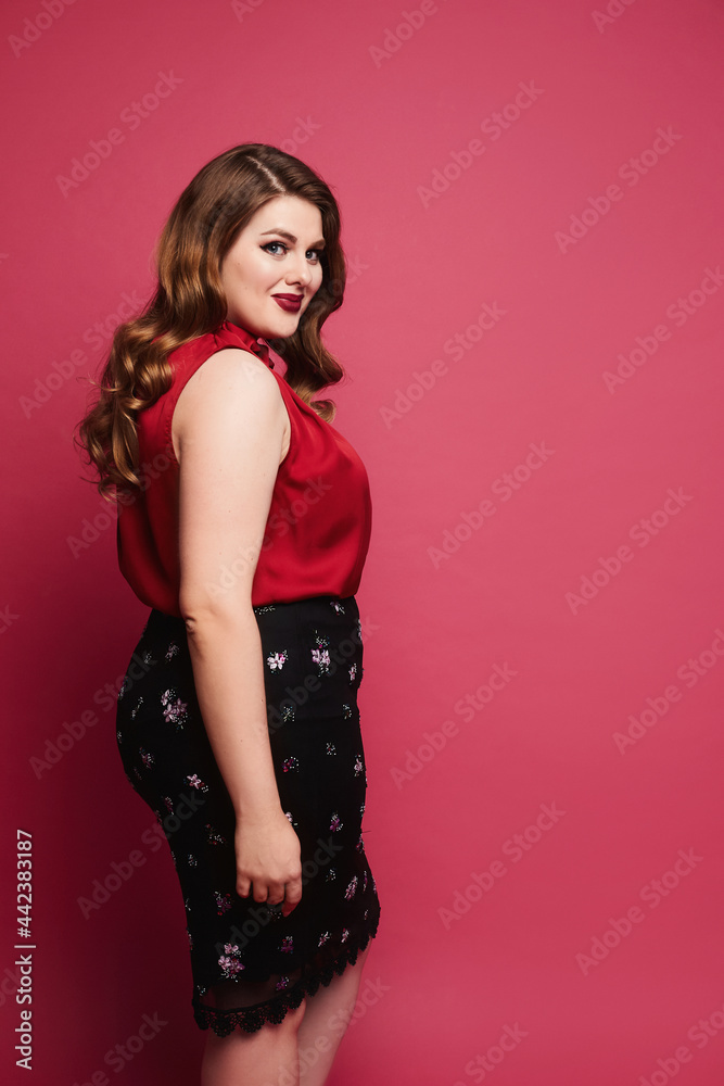 Young plus-size model girl in red satin blouse and skirt posing over pink  background. Happy chubby woman in modish outfit over pink background Stock  Photo | Adobe Stock