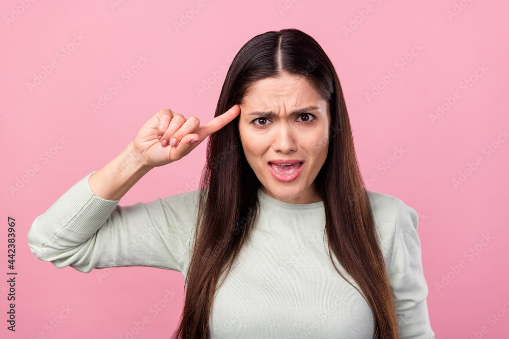 Photo of unhappy stressed young woman point finger head tease accuse isolated on pink color background Photo of unhappy stressed young woman point finger head tease accuse isolated on pink color background