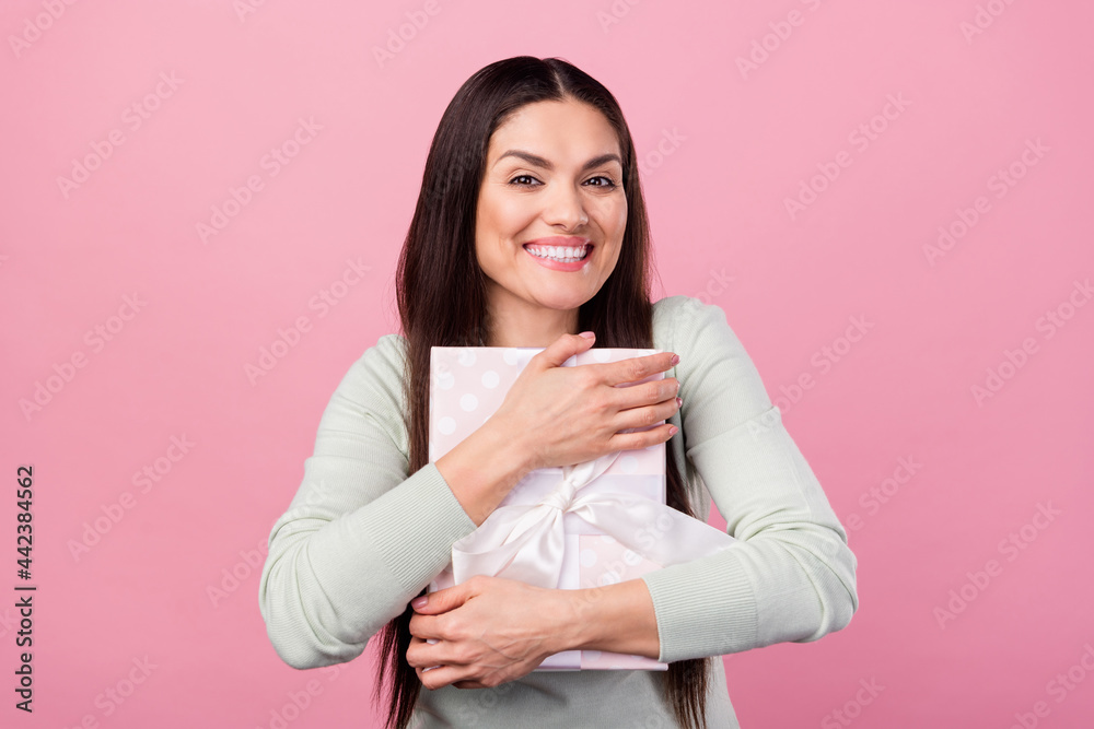 Photo of charming nice happy young woman hug present box birthday isolated on pink color background Photo of charming nice happy young woman hug present box birthday isolated on pink color background