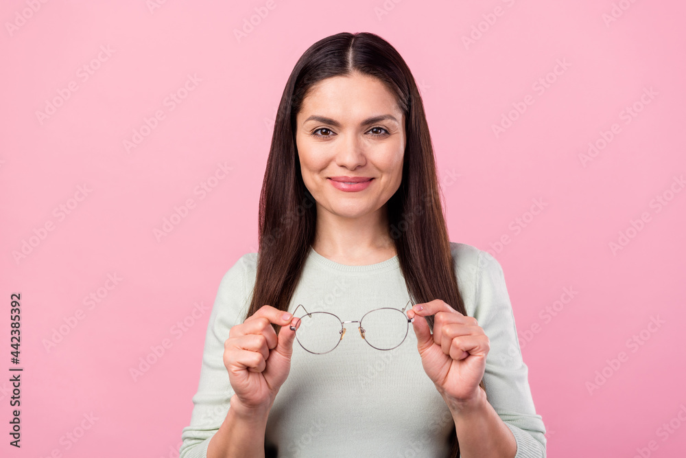 Photo of attractive charming nice mature woman hold hands glasses lady isolated on pink color background Photo of attractive charming nice mature woman hold hands glasses lady isolated on pink color background