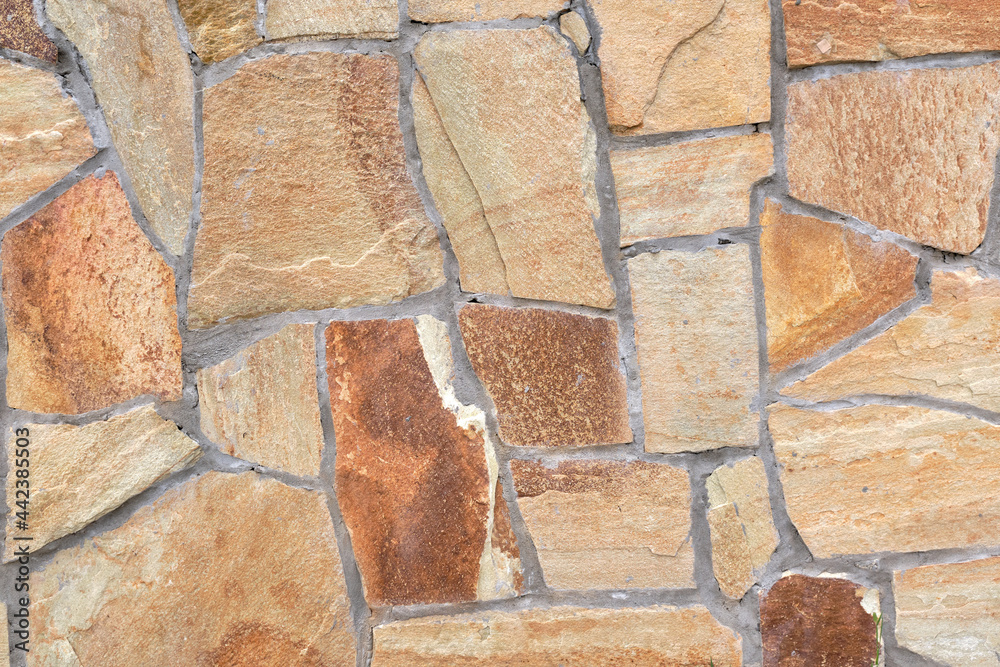 Fragment of a wall from a chipped stone, stone wall texture. decorative stone, different colors. Fragment of a wall from a chipped stone, stone wall texture. decorative stone, different colors.