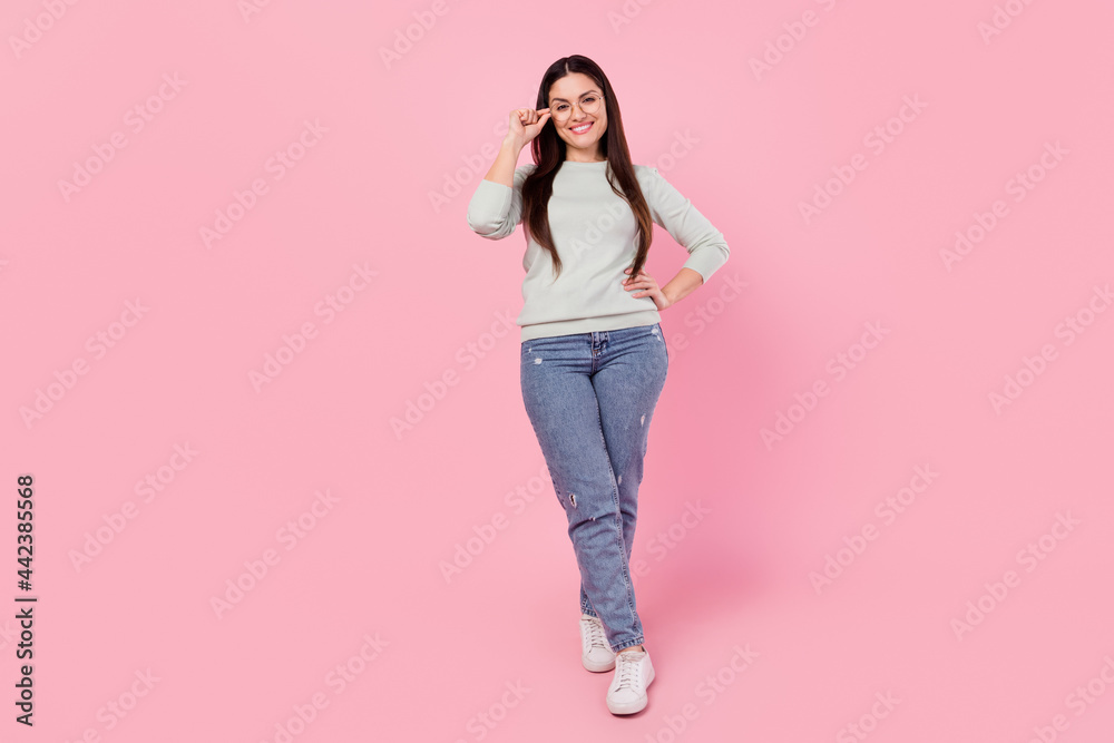 Full body photo of happy nice cheerful young woman hold hand waist wear glasses isolated on pink color background Full body photo of happy nice cheerful young woman hold hand waist wear glasses isolated on pink color background