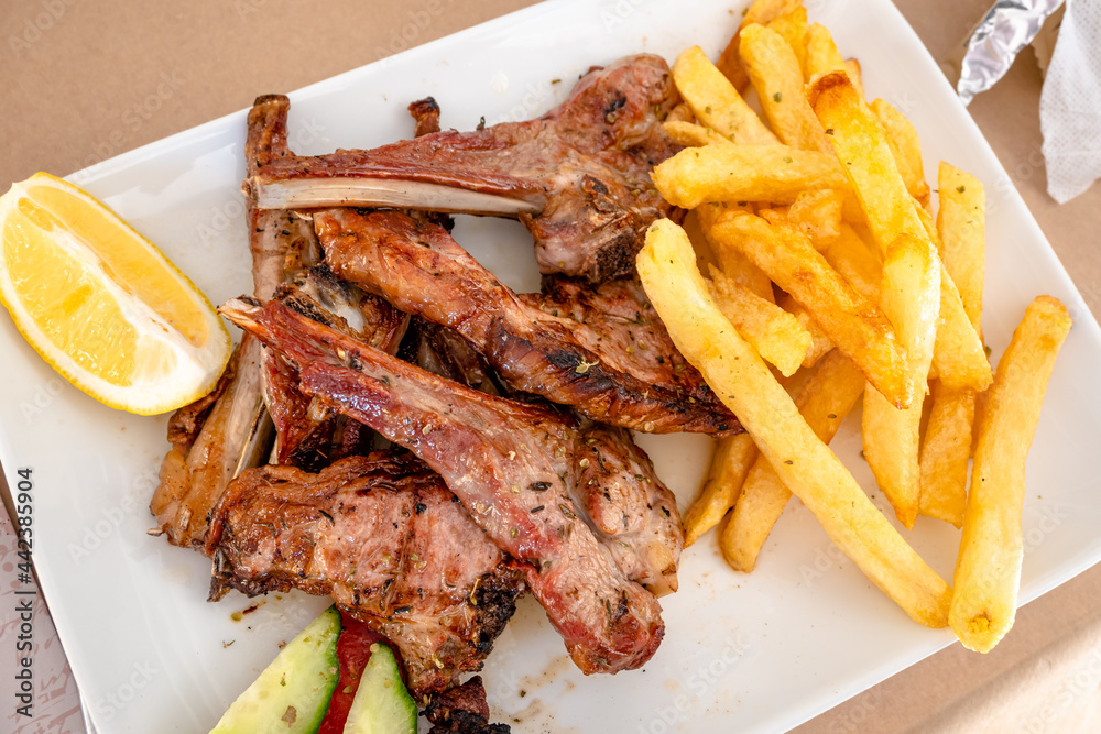 Grilled lamb chops served with fries in restaurant. Traditional Greek dish.