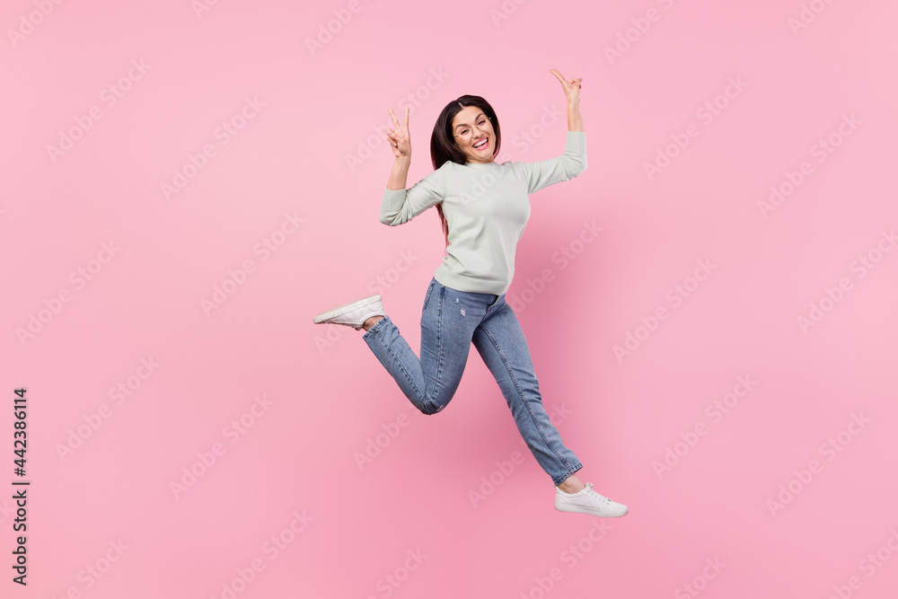 Full size photo of pretty cheerful nice positive woman jump up make v-sings cool isolated on pink color background