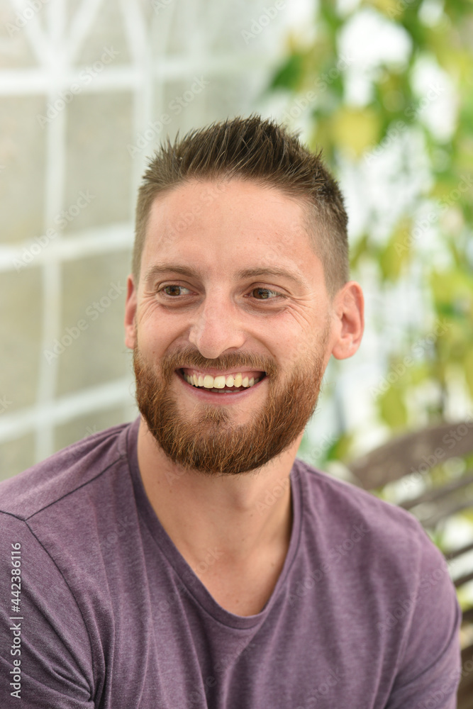 Fototapeta premium young bearded man smiling with purple clothes
