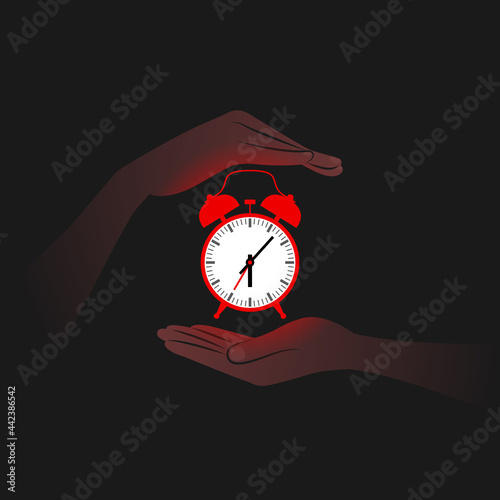 Red alarm clock and person's hands near it in darkness