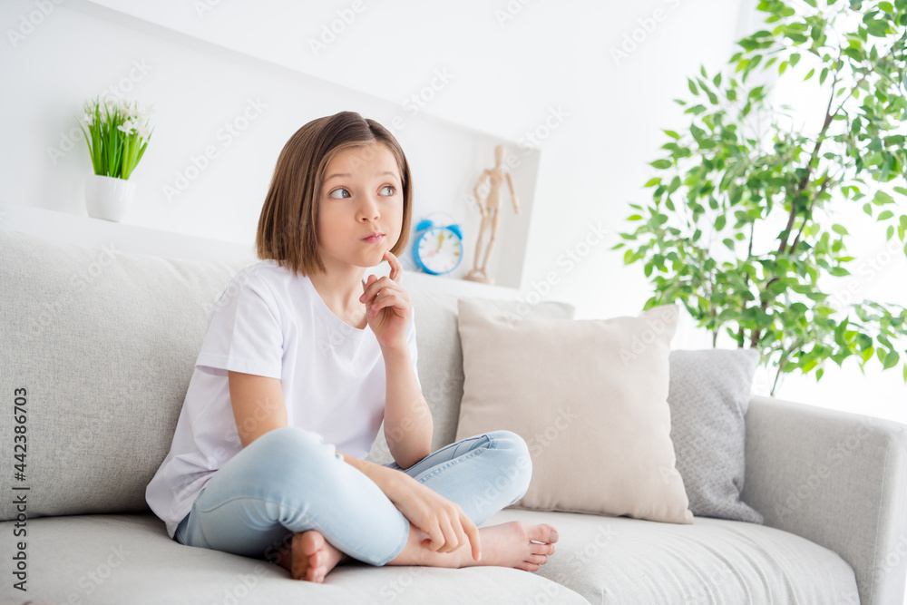 Photo portrait little girl sitting on sofa at home dreamy thoughtful Photo portrait little girl sitting on sofa at home dreamy thoughtful