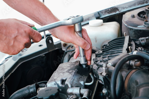 Car repair. Auto mechanic working on car engine in mechanics garage. Repair service. close-up shot