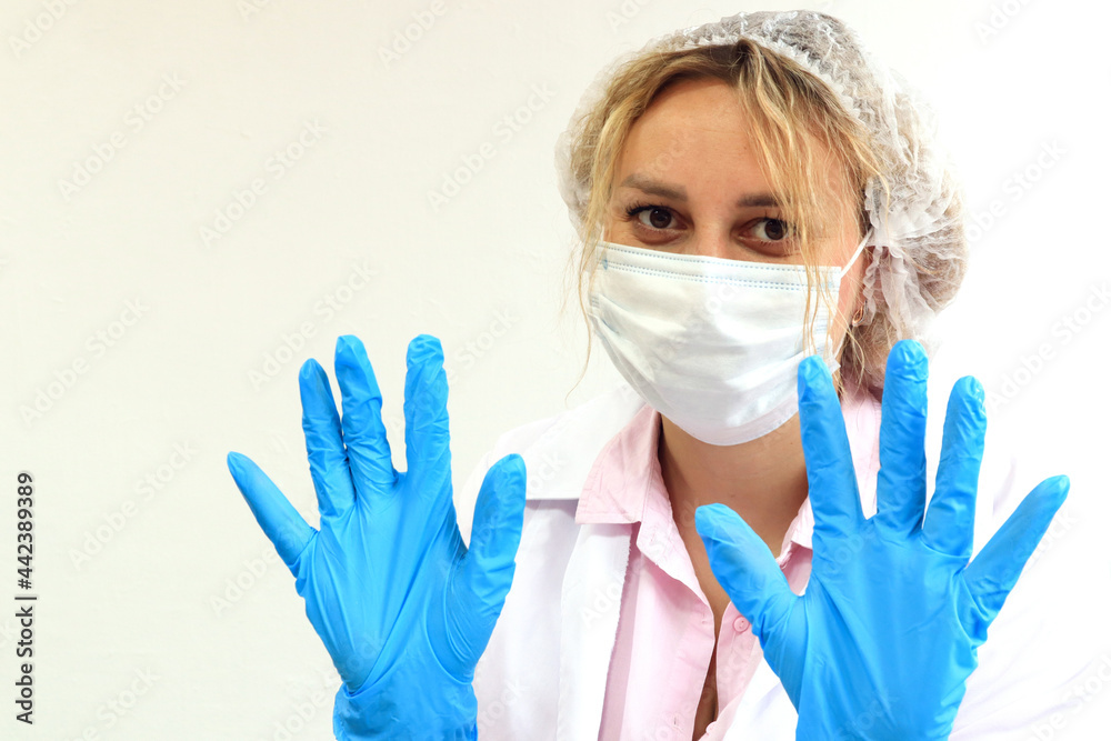 The concept of vaccination among the population. A doctor in a medical mask holds his gloved hands in front of him, ready for work, close-up The concept of vaccination among the population. A doctor in a medical mask holds his gloved hands in front of him, ready for work, close-up