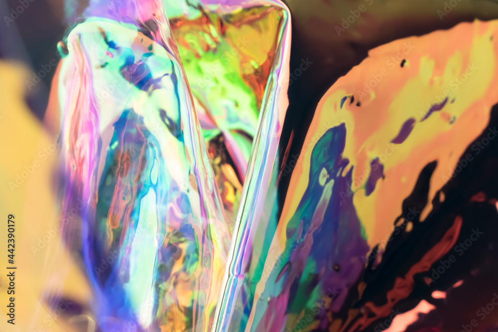 Fototapeta premium Defocused iridescent holographic background. Blurred colorful texture of wrinkled foil.