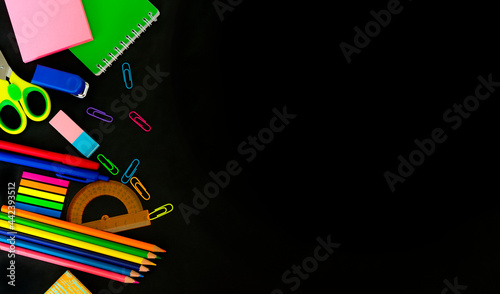 Multicolored assorted stationery on black background