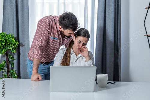 Male boss making woman worker stressed in the company office on her probation work period to see how she will handle with stress on her job  photo