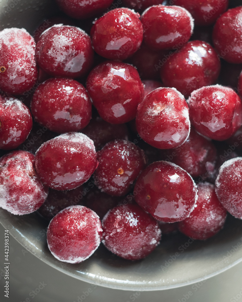 Ripe frozen cherries on grey plate, close-up Ripe frozen cherries on grey plate, close-up