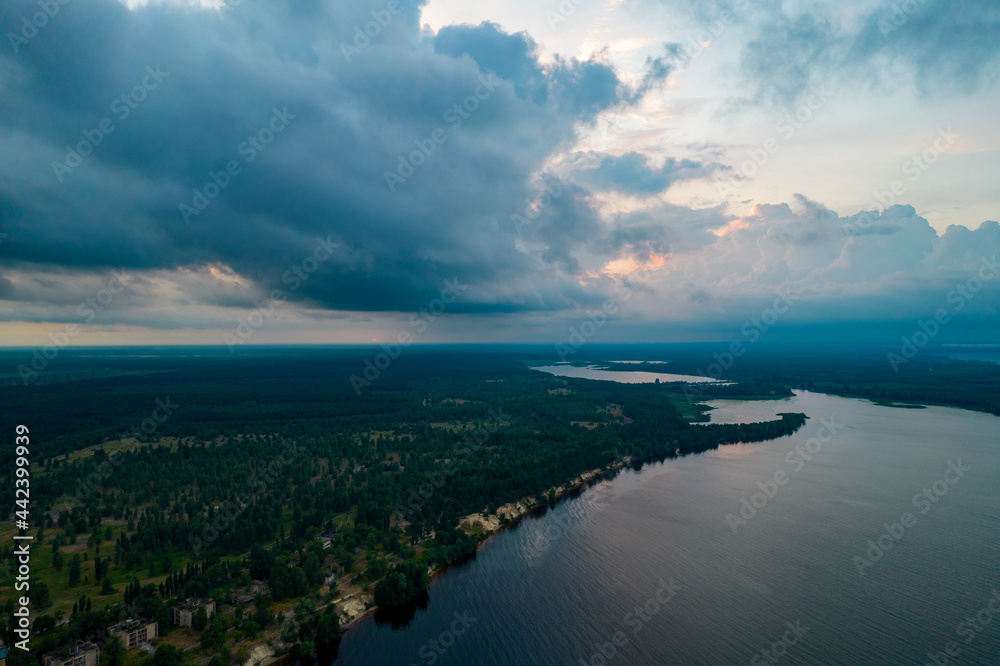 Aerial view of rain clouds over the valley and the Kiev Sea at sunset
