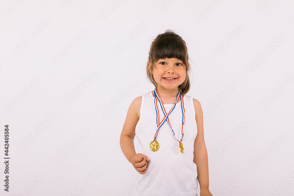 Little girl with dark hair with sports champion medals. Sport and victory concept Little girl with dark hair with sports champion medals. Sport and victory concept