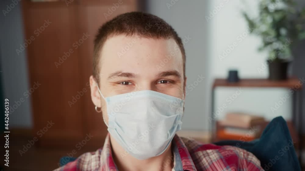 Portrait of brutal teenager man with a nose piercing and earrings, wearing coronavirus protection medical mask, British brown-eyed model smiling, looking in camera, posing. Portrait of brutal teenager man with a nose piercing and earrings, wearing coronavirus protection medical mask, British brown-eyed model smiling, looking in camera, posing.