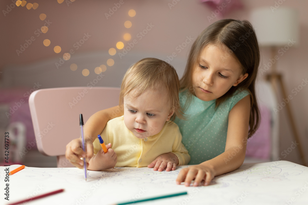 two children draws at the table in the room, two children draws at the table in the room,
