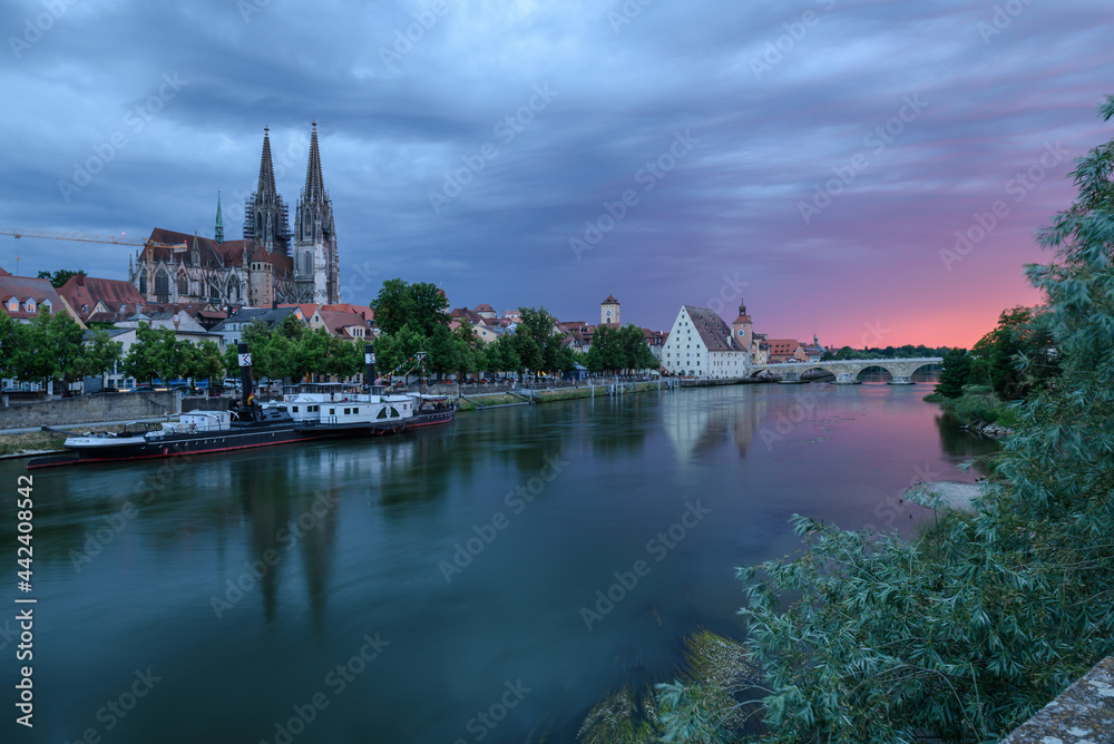 Regensburg am Abend bei Dämmerung mit Dom, steinerner Brücke und Donau