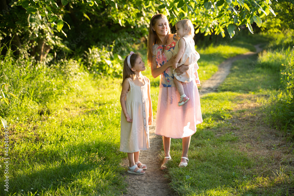 Fototapeta premium Mom and two daughters in nature