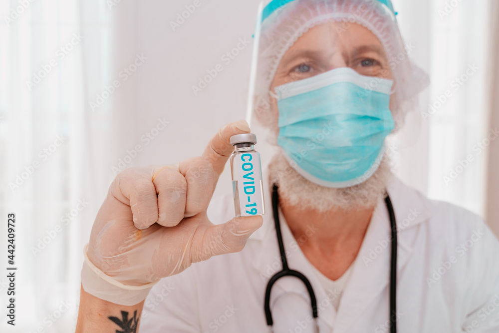 Doctor with mask and syringe is ready to administer the vaccine against covid 19 Doctor with mask and syringe is ready to administer the vaccine against covid 19