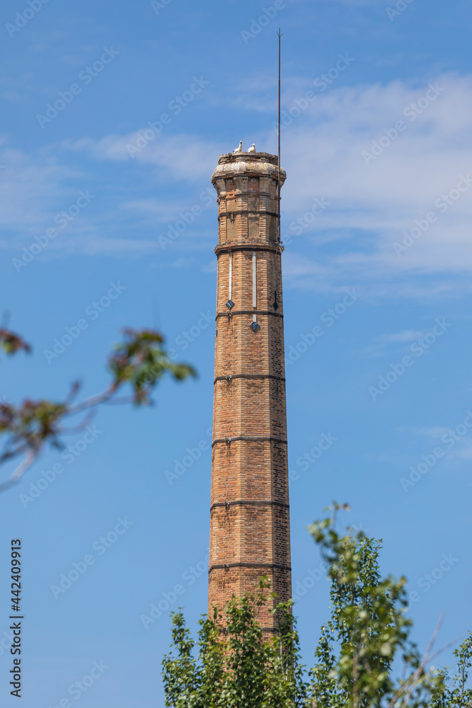 Old industrial chimney of the old pottery factory in Segovia, next to the Eresma river, now inhabited by storks