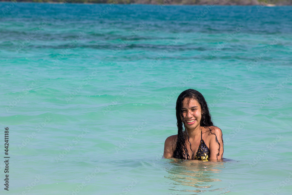 Enjoying the summer in the Venezuelan Caribbean. Beach girl enjoys crystal clear waters, Chichiriviche, Cayo Muerto - Morrocoy National Park
