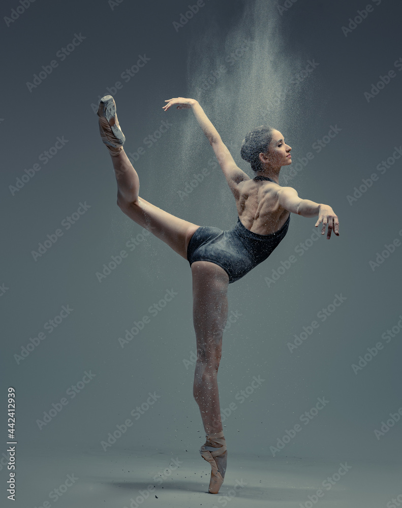 Professional ballerina dancing in studio against gray background - obrazy, fototapety, plakaty 