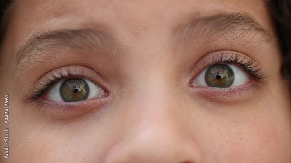 Child eyes wide open with green eye staring camera macro close-up Child eyes wide open with green eye staring camera macro close-up