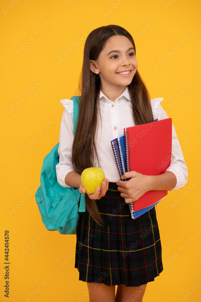 happy child with backpack and workbooks hold apple lunch in school uniform, september. happy child with backpack and workbooks hold apple lunch in school uniform, september.