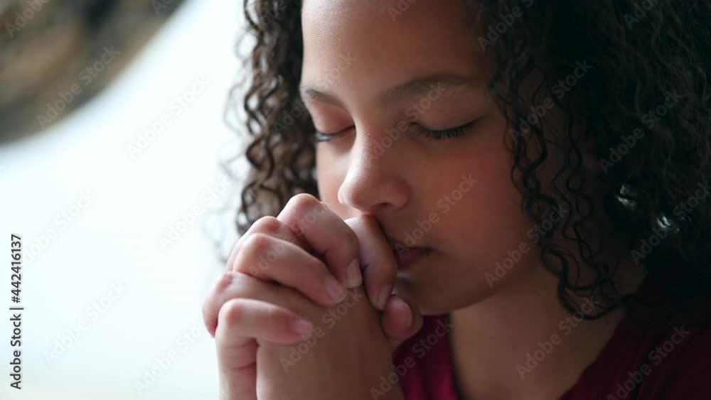 Little girl praying to God, spiritual child in prayer