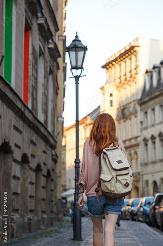a girl walks through the streets of an old European city
