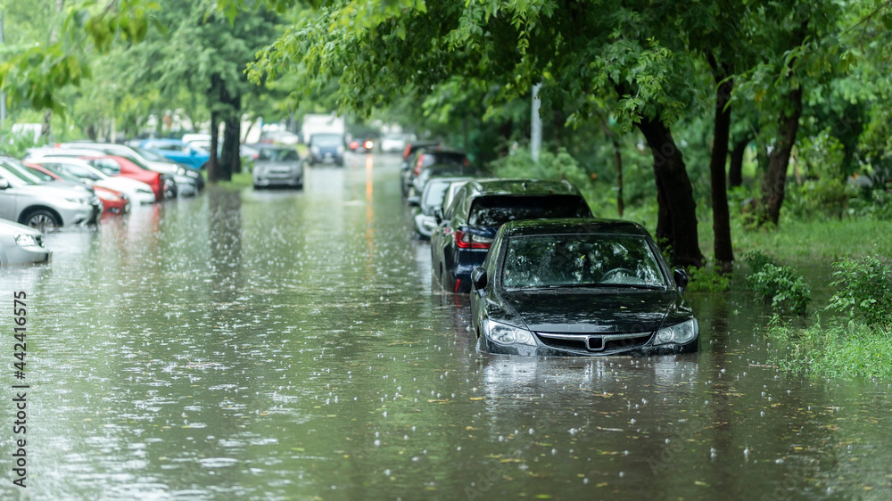 Flooded cars on the street of the city. Street after heavy rain. Water could enter the engine, transmission parts or other places. Disaster Motor Vehicle Insurance Claim Themed. Severe weather concept - obrazy, fototapety, plakaty 