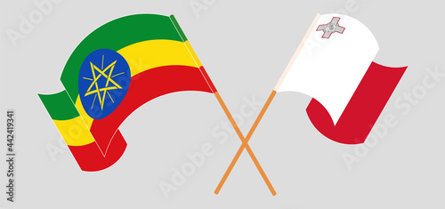 Crossed and waving flags of Ethiopia and Malta