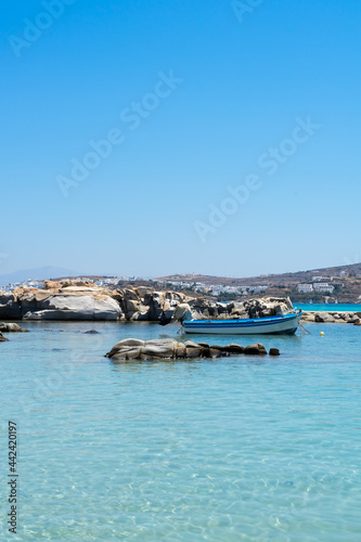 typical fishing boat on crystal clear turquoise sea water of Kolymbithres beach  Paros island  Greece