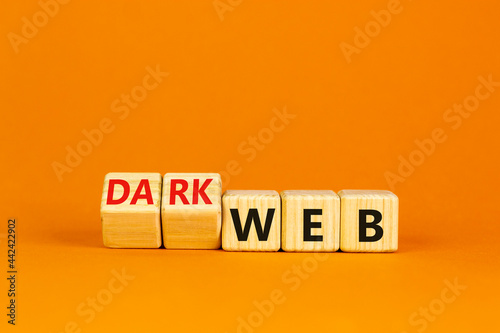 Dark web symbol. Turned wooden cubes and changed the word web to dark web. Beautiful orange background. Business, dark web concept. Copy space.