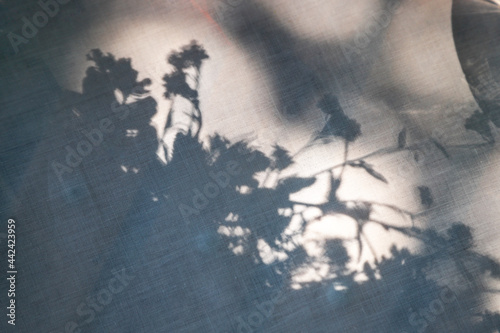 Blue floral shadows on linen fabric as a background