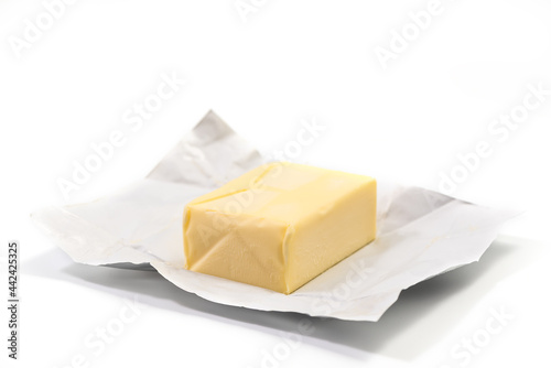 Traditional butter block unwrapped for use as a baking ingredient isolated on white background. Close up of a Butter Block