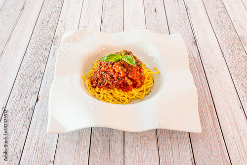 Recipe for spaghetti with minced meat cooked with bolognese sauce on white plate