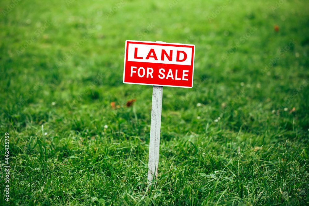 land for sale plate sign, green grass background