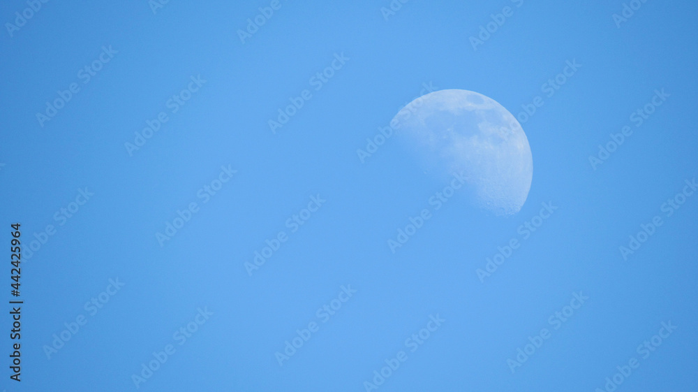 Daytime moon on a blue sky background