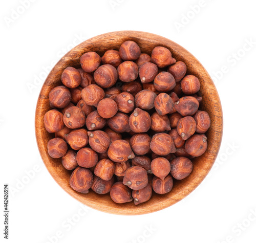 Pile of brown chickpeas in wooden bowl, isolated on white background. Brown chickpea. Garbanzo, bengal gram or chick pea bean. Top view.