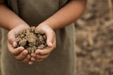 Soil in children's hands for planting trees. Selective focus.