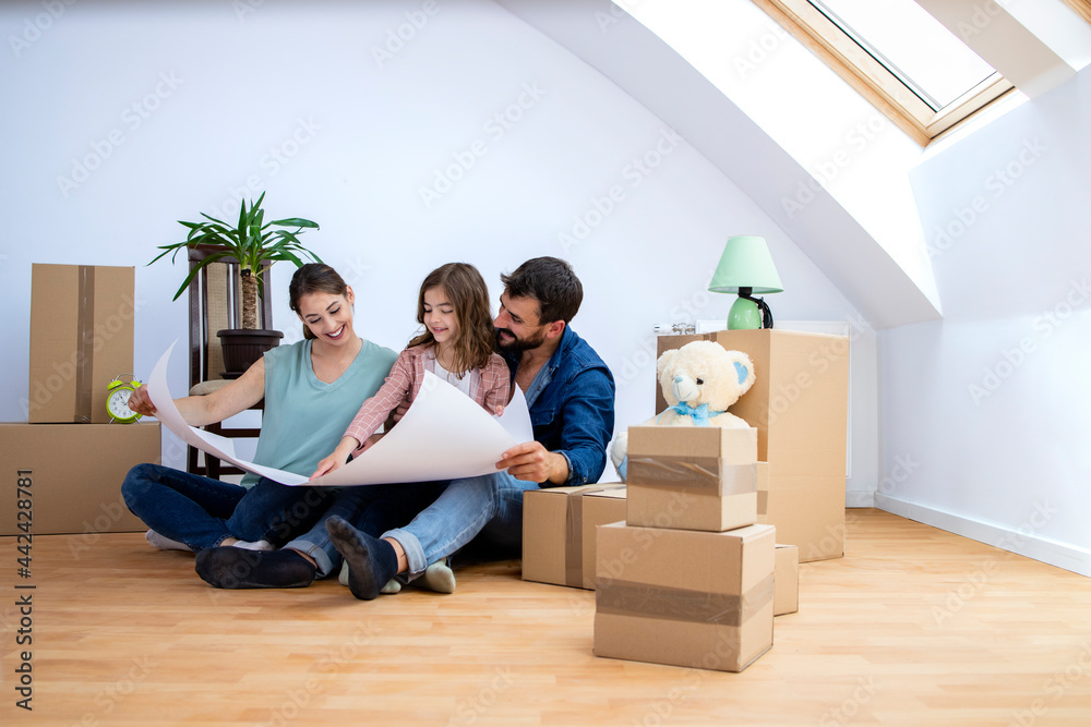 Happy family in their new home looking at project layout and planning house decoration. Happy family in their new home looking at project layout and planning house decoration.