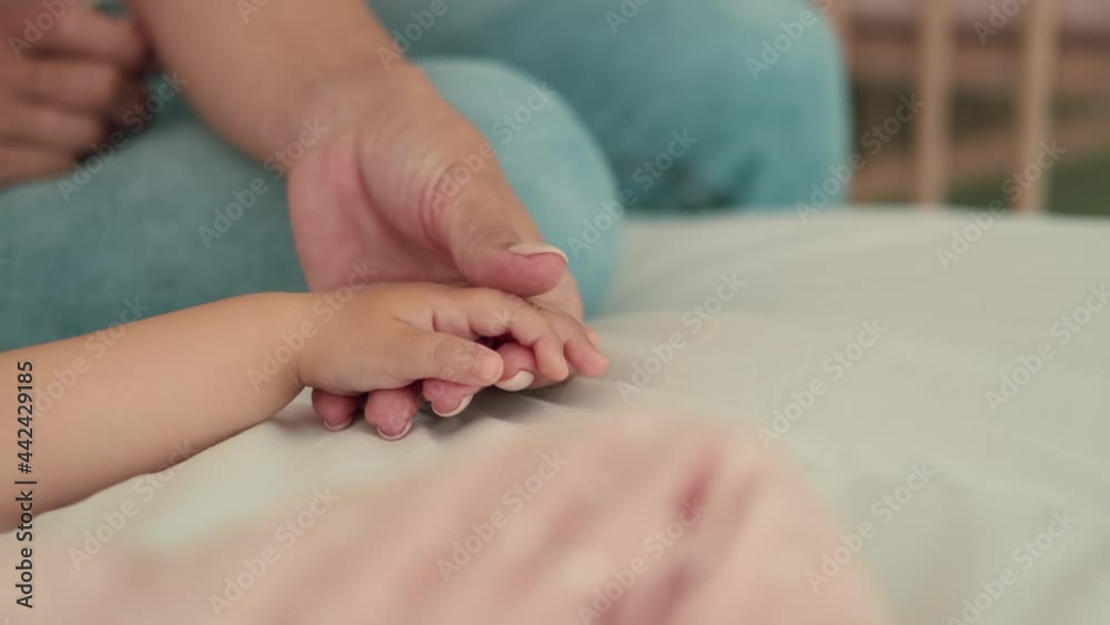 Childcare at Home, Child Protection, New Life, Leisure with Baby. Caring mom stroking the palm of the child Childcare at Home, Child Protection, New Life, Leisure with Baby. Caring mom stroking the palm of the child
