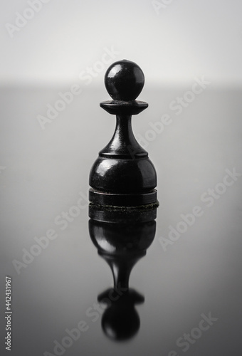 the pawn chess piece on white background with reflection in table
