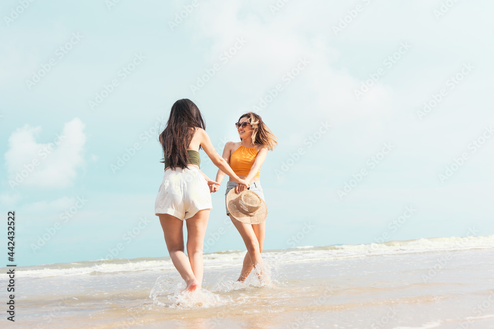 Two Asian women in summer casual clothes play in the sea on the Beach Having Fun. Two Asian women in summer casual clothes play in the sea on the Beach Having Fun.