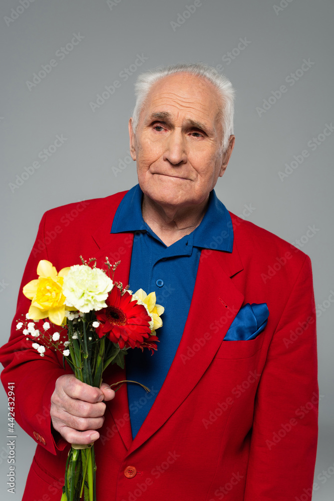 elderly man in stylish clothes standing with bouquet of flowers isolated on grey elderly man in stylish clothes standing with bouquet of flowers isolated on grey
